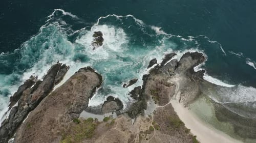 Drone Orbiting Shot of Cliffside and Beautiful Ocean Water Sparking in the Sun, Indonesia