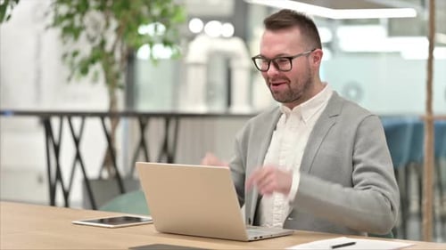 Man Video Calling on Laptop in Office
