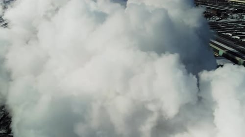 Un paso elevado sobre una gran nube de vapor en una zona industrial