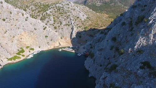 Petit port de pêche dans une vallée étroite entre les montagnes rocheuses aux parois abruptes