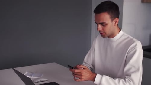 Thoughtful Serious Young Man Student Writer Sit at Home Office Desk with Laptop Thinking of