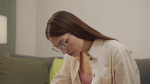 Woman Working on Laptop and Writing Notes at Home