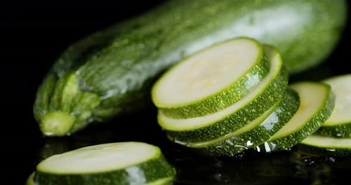 A Bunch of Pieces of Zucchini Falls Into the Water.