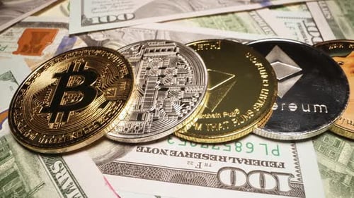 Vue rapprochée des différentes monnaies cryptées alignées sur des billets de 100 dollars