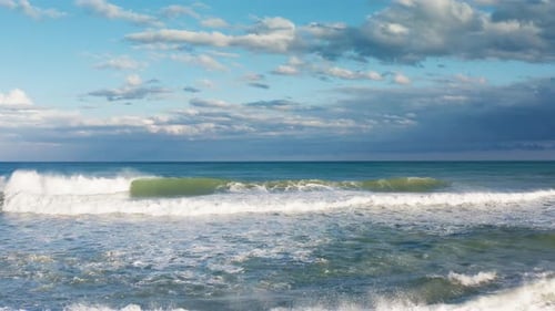 Waves of the Sea at the Morning Crashing in Windy and Cloudy Day