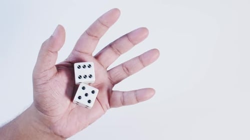 Hand Holding Two Dice Against White Background