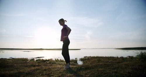 Silhouette of Young Sporty Woman Engaged in Gymnastics on Background Sky and Lake. V3