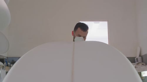 Male surfboard maker in his workshop