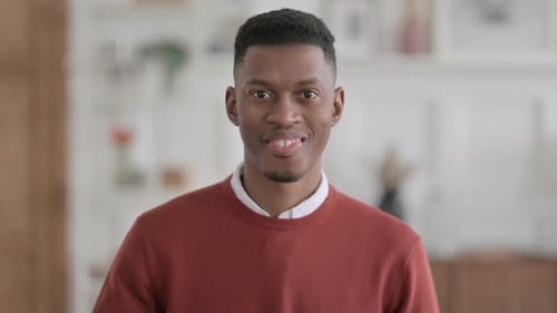Smiling Young Man Gives Thumbs Up Gesture