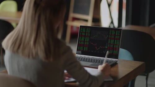Asian Businesswoman Analyzing a Graphic of a Stock Exchange Chart