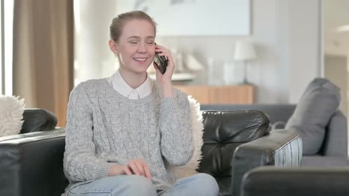 Woman Talking on Phone while Sitting in Armchair