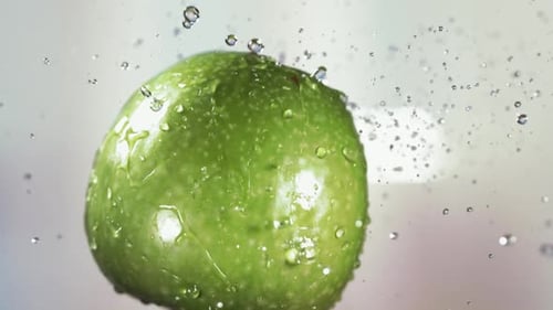 Flying of Green Apple in White Kitchen Background in Slow Motion