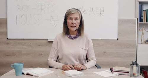 Woman Teacher Talking into Headset in Classroom