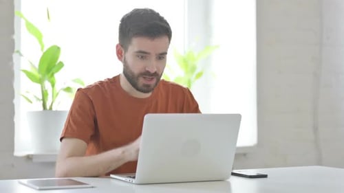 Young Adult Typing on Laptop and Celebrating Success