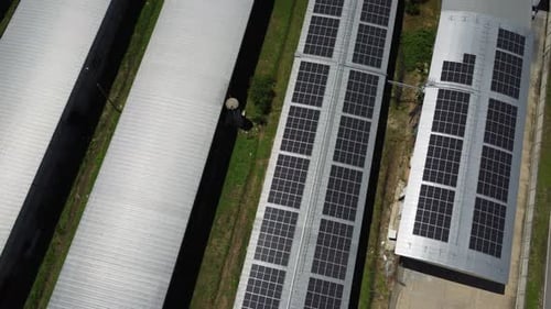 Aerial view of Solar panels installed on a roof of a large industrial building or a warehouse.