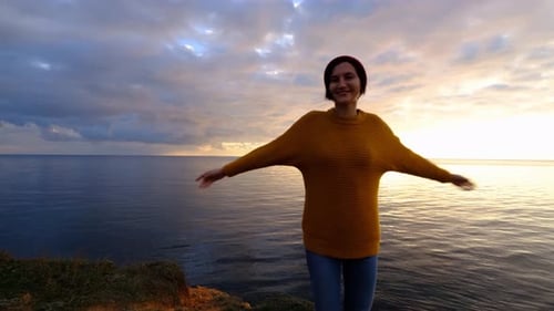 Woman Enjoying Beautiful Colorful Sunset Above Sea From Cape