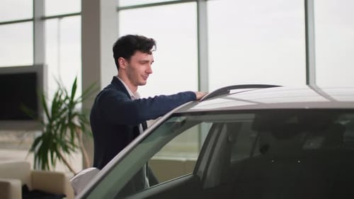 Portrait of Happy Male Owner of New Car with Keys in His Hands in Automobile Dealership Smiling and