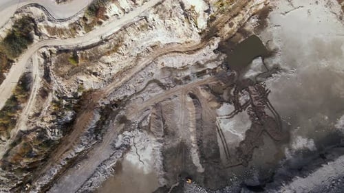 Aerial view of Slope operating granite quarry with mining equipment on ledges