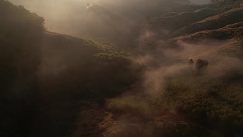4K aerial view from a drone flying over the valley, fog in the morning.