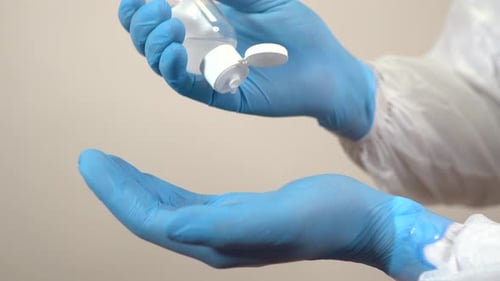 Using Hand Sanitizer with Blue Gloves