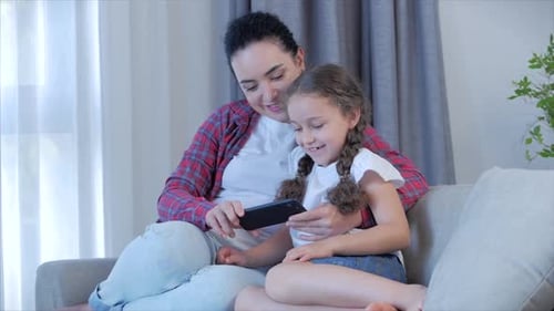 Mother and Child Enjoying Phone Together at Home