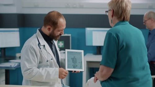 Männlicher Arzt zeigt menschliche Skelett-Abbildung auf digitalem Tablet
