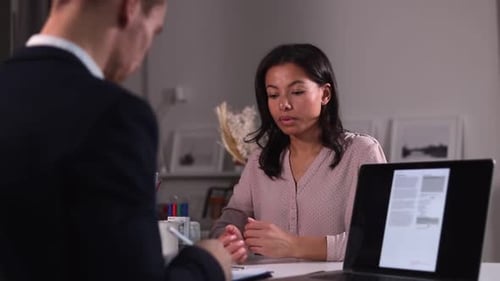 Woman Discussing Documents in Modern Workplace
