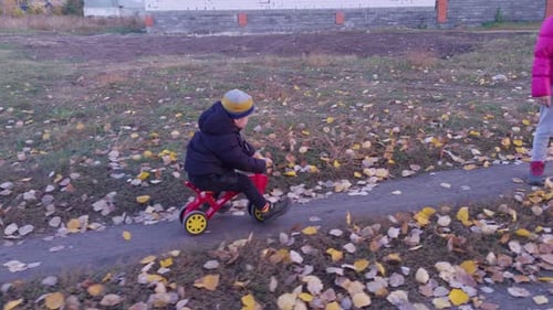 Child on Tricycle Riding on Dirt Path