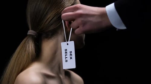 Woman with "Sex Sells" Tag in Ear