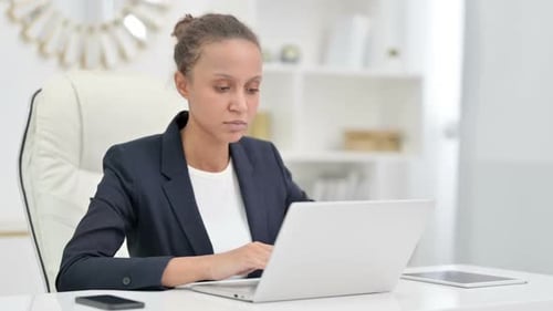 Focused African Businesswoman Working on Laptop in Office