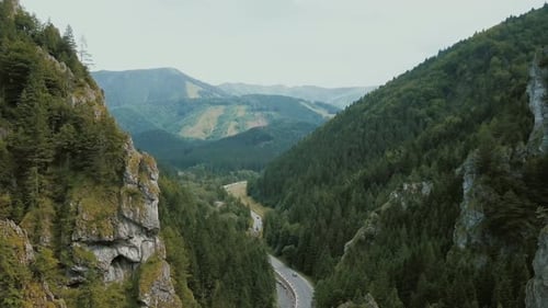 Aerial View of a Mountain Road in a Beautiful Deep Gorge. Cars Move on a Mountain Road