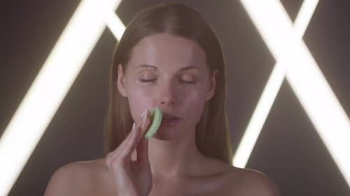 Woman Wiping Face with Cleansing Sponge