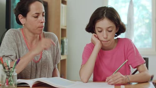 Child Doing Homework with Adult at Table