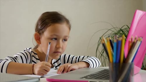 Girl Learning with Laptop and Writing Indoors