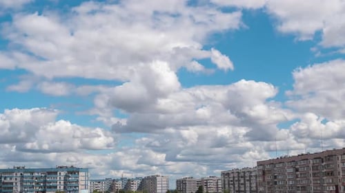 Cumulus Cirrus-Wolken bewegen sich am blauen Himmel über mehrstöckigen Gebäuden in der Stadt