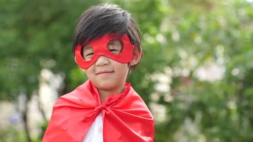 Asian Child In In Superhero Costume Playing In The Park