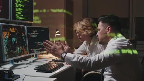 Colleagues Coding Together Late At Night