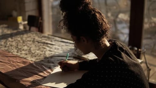 Woman Drawing at Table with Natural Light