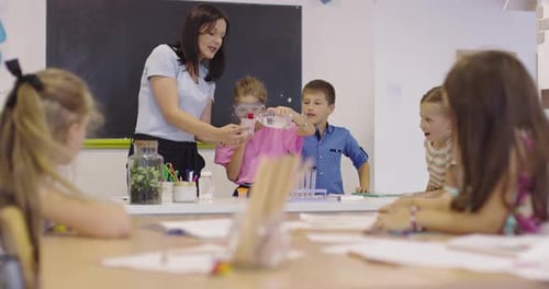Elementary School Science Classroom Enthusiastic Teacher Explains Chemistry to Diverse Group of