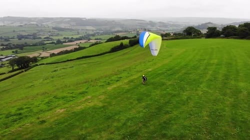 Aerial shot of a Paraglider ready to take off from a hill in Devon England
