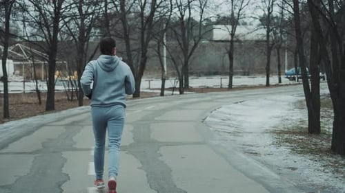 Active Woman Jogging on Road in Winter
