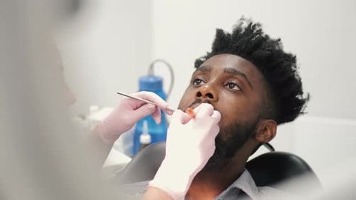 Dentist Examining a Patient's Teeth in the Dentist Office
