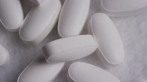 White Oval Pills Piled in Close Up Shot