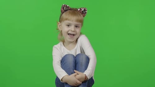 Adorable Little Girl Sitting on Green Screen Background
