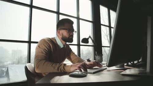 Caucasian Man Is Working on Laptop Computer at Style Loft Office