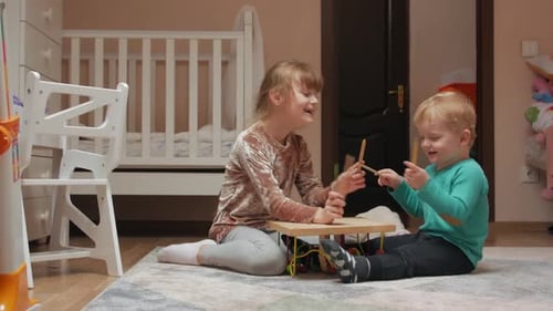 Children Playing Xylophone Together on the Floor