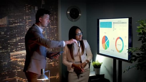 Financial Analysis Meeting in Modern Office at Night