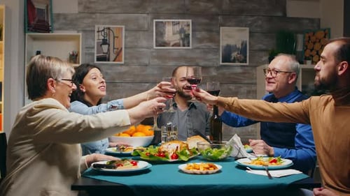 Family Raising Glasses for Dinner Toast Indoors