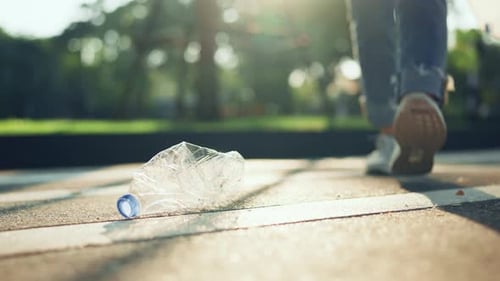 Picking up Discarded Plastic Bottle in Park