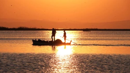 Sunset And Fishing Boat In Calm Sea